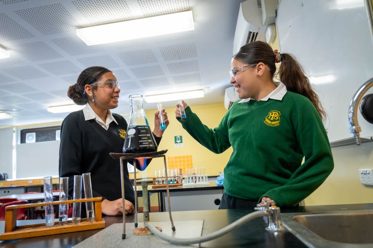 photo shows two students working in the science lab conducting an experiment
